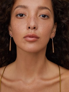 Close-up of wood grain teardrop earrings on model for elegant face-slimming look