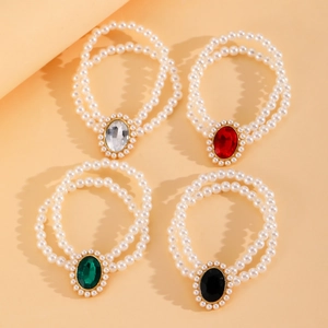 Détail de bracelets en perles avec pendentifs en cristal blanc, rouge, vert et noir