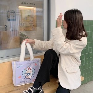 Detailansicht lila Canvas-Tasche mit Hasen-Print und weißen Plüschgriffen