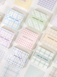 Flat lay macro view of Macaron colored grid memo pads with English labels in neat composition