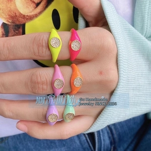 Close-up of colorful enamel copper rings with micro-pave crystals on finger