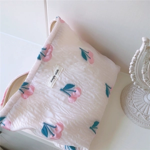 Détail de la trousse de maquillage matelassée à motif cerise avec étiquette tissée