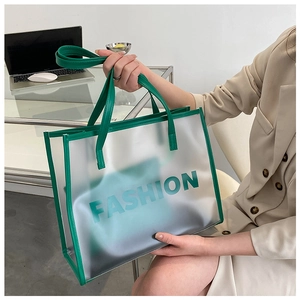 Detail of green transparent tote bag with leather handles shown by model in office