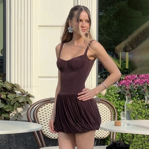 Gros plan détaillé sur la texture plissée de cette robe courte moulante en marron foncé