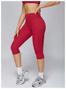 Detail of red high-waisted brushed yoga shorts and matching sports bra in a studio setting