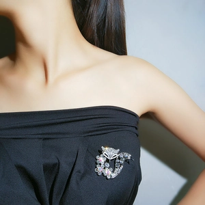 Sparkling crystal fox brooch with floral detail pinned on a elegant black garment