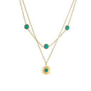 Collana a doppio strato in acciaio dorato con pendente sole turchese su sfondo bianco