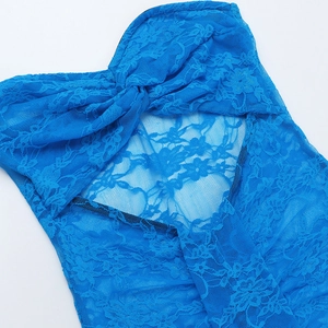 Dettaglio macro del tessuto in pizzo blu e del nodo centrale sul vestito da spiaggia