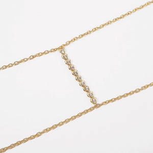 Close-up of gold body chain featuring sparkling rhinestone-encrusted heart pendants