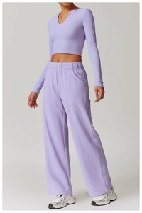 Detail of lavender slim-fit long sleeve yoga top and high-waisted wide-leg sports pants