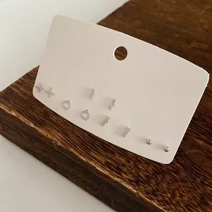 Set of six minimalist silver geometric stud earrings with zircons on display card