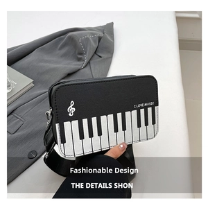 Close-up of piano key pattern and I LOVE MUSIC silk print on black PU leather handbag