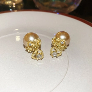 Macro shot of elegant champagne pearl stud earrings with sparkling heart-shaped zirconia drops