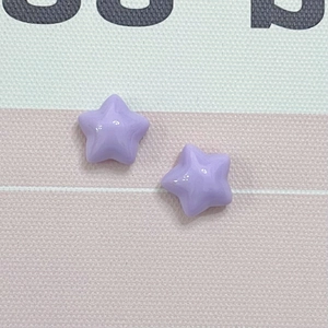 Close-up of purple star resin charms with a glossy finish for DIY phone cases and jewelry