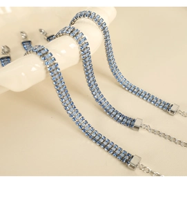 Macro d'un bracelet argenté avec trois rangées de strass bleu clair et chaîne d'extension