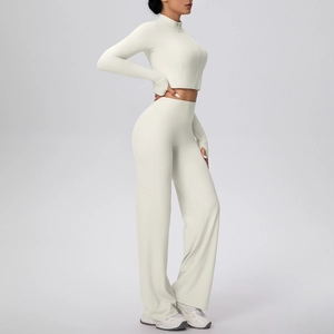 Détail d'un ensemble de yoga crème avec haut zippé et pantalon large taille haute