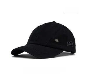 Detail of embroidered Freestyle text and metal logo on a black cotton baseball cap