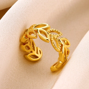 Detailed view of gold leaf ring with matte textures on elegant champagne satin background