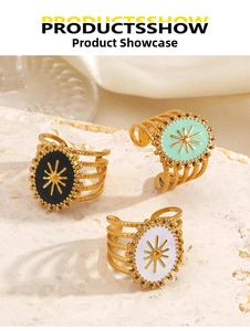 Detailed view of bohemian gold rings with black, white, and mint green enamel sun motifs