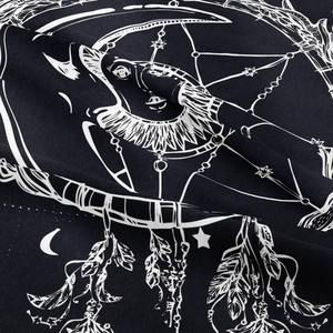 Macro detail of Bohemian tapestry showing black fabric texture with moon and star prints