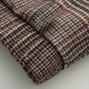 Vue détaillée du tissu en laine pied-de-poule épais en tons marron, noir et blanc