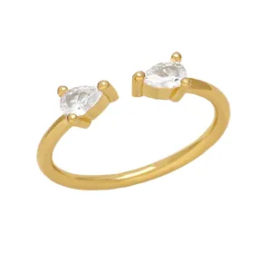 Close-up of adjustable gold ring with two pear-cut crystal stones on white background