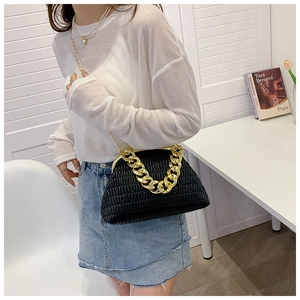 Détail du sac plissé noir avec grosse chaîne dorée et fermoir métallique chic