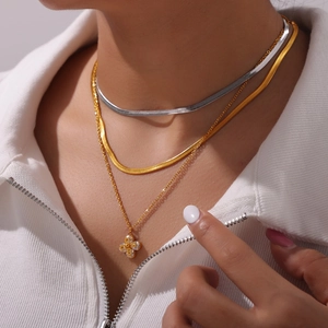 Layered gold and silver blade chains with clover zircon pendant in titanium steel