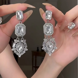Detailed view of silver flower earrings with crystals showing the long elegant hanging style