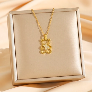 Collier en acier titane avec pendentif ours doré évidé et cristaux sur une boîte cadeau