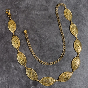 Detailed close-up of vintage golden alloy belt featuring floral engraved turquoise motifs