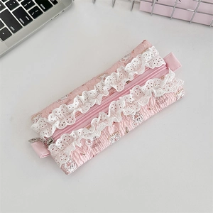 Close-up of pink quilted pencil case featuring white lace trim and cute bunny patterns
