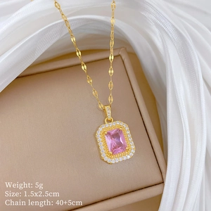 Détail du collier doré avec pendentif carré rose serti de cristaux sur fond de soie