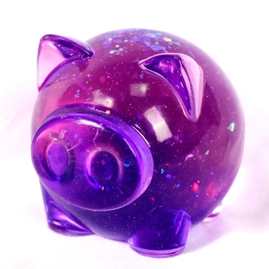 Macro detail of cute purple glitter resin pig ornament with sparkly sequins and glossy finish
