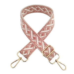 Detail of adjustable woven jacquard strap in pink and beige with gold metal hooks