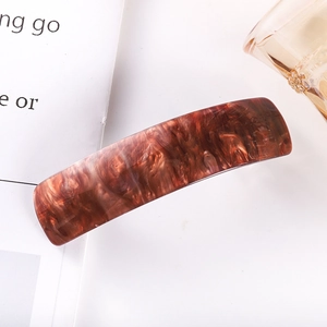 Detailed view of rectangle tortoiseshell hair clip with premium acetate texture and spring clip