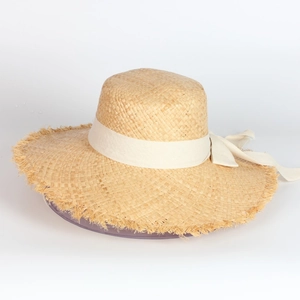 Wide brim raffia straw sun hat with frayed edges and cream bow for beach vacations