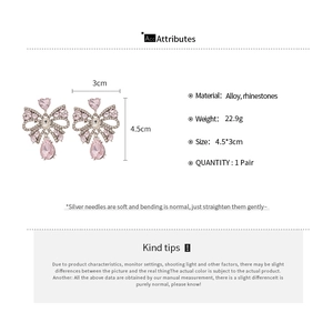 Detail view of pink bow earrings with rhinestone water drop tassels and dimensions