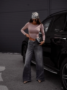 Outdoor shot of pink long sleeve ribbed top paired with high waist wide leg grey jeans