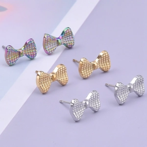 Dettaglio degli orecchini a fiocco in argento, oro e iridescente con trama a rete metallica