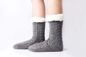 Detailed knit texture of grey slipper socks with soft white fleece lining and cuffs