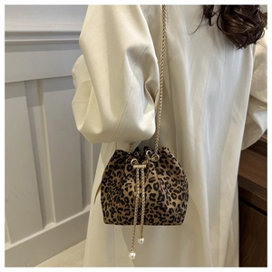 Detail of leopard print bucket bag with gold chain strap and pearl drawstring tassels