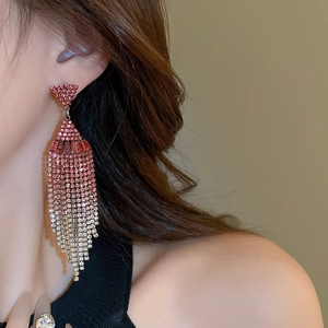 Close-up of geometric tassel earrings with pink gradient rhinestones on model