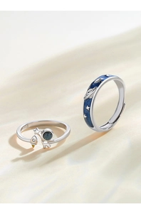 Detailed view of astronaut and rocket rings with blue enamel stars and S925 silver finish