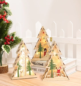 Close-up of three wooden Christmas tree ornaments with warm LED lights and reindeer motifs
