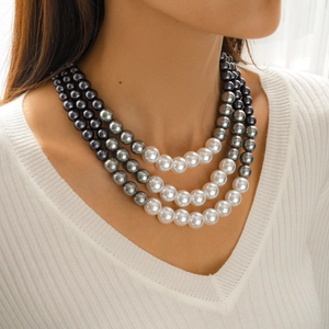 Detailed view of triple-layer pearl necklace with white, light gray, and dark gray pearls