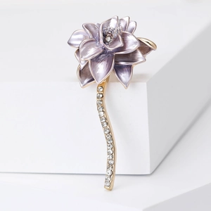 Detailed view of purple 3D lotus brooch with gold stem and sparkling crystals