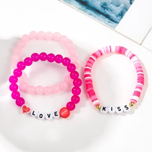 Close-up of three handmade beaded bracelets with LOVE and KISS letters and heart charms