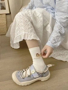 Détail de chaussettes en coton brodées chiot avec des baskets en daim bleu ciel