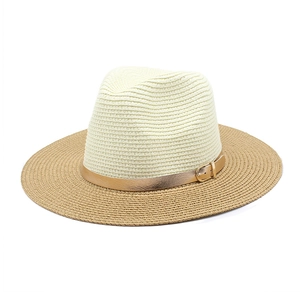 Detailed texture of two-tone woven straw sun hat with stylish gold buckle belt